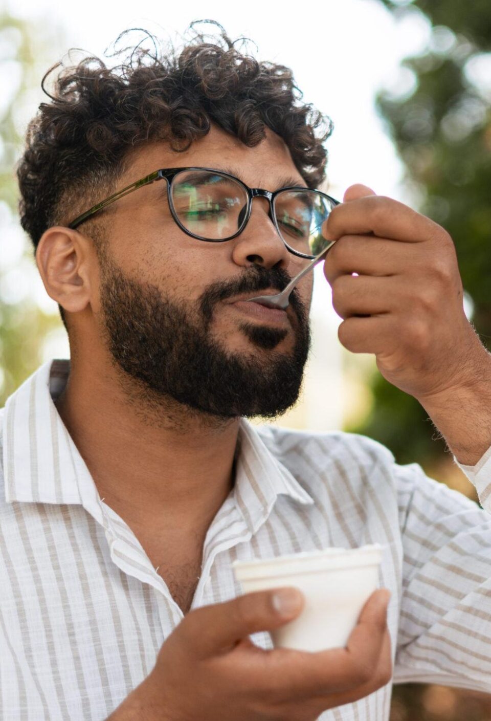 Young man enjoying a tasty dessert outdoors in a park
